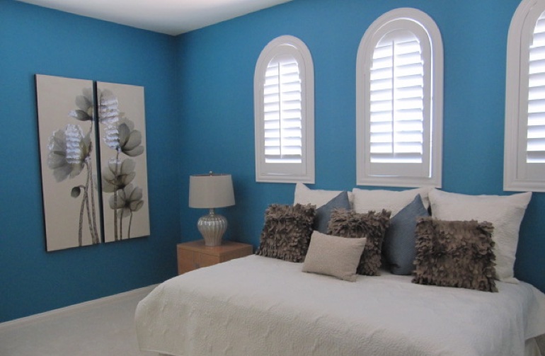 Arched plantation shutters in contemporary bedroom